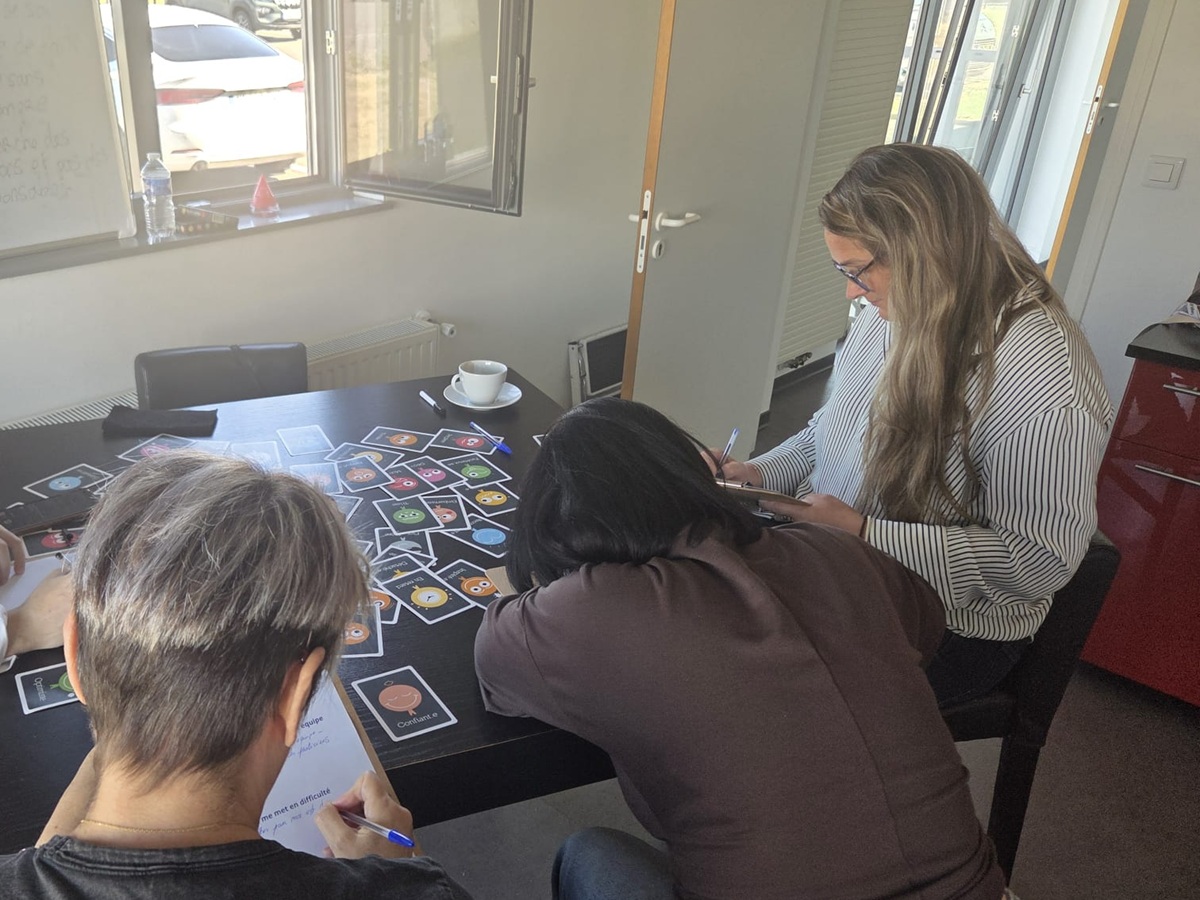 Équipe réunie autour de supports de communication pendant un atelier collectif à Chauny