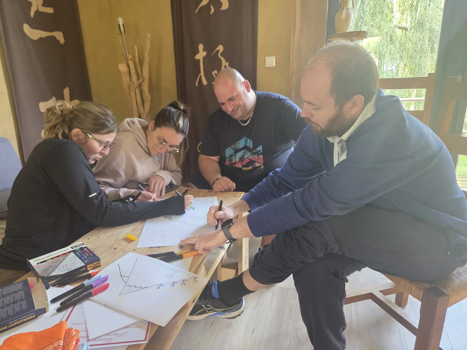 Participants dessinant ensemble un blason des valeurs pendant une journée de cohésion