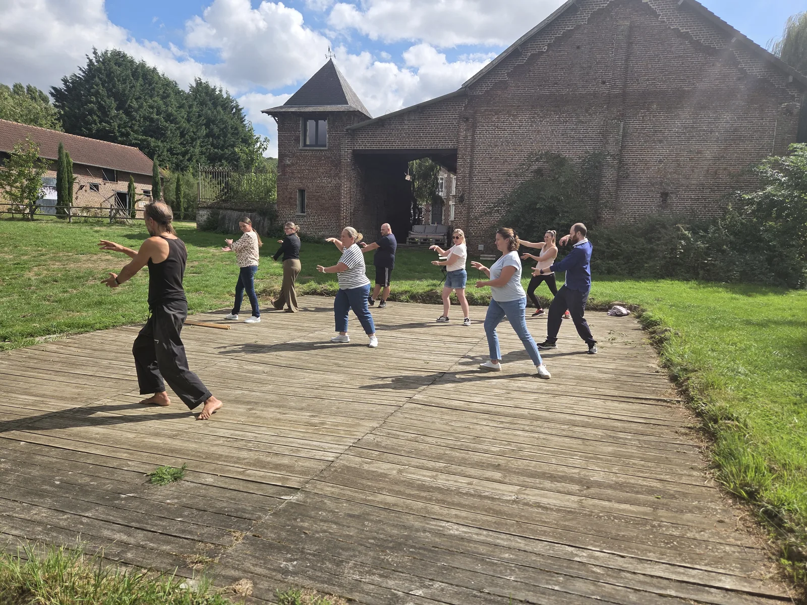 Groupe participant à une initiation au tai-chi en extérieur pendant une journée de cohésion